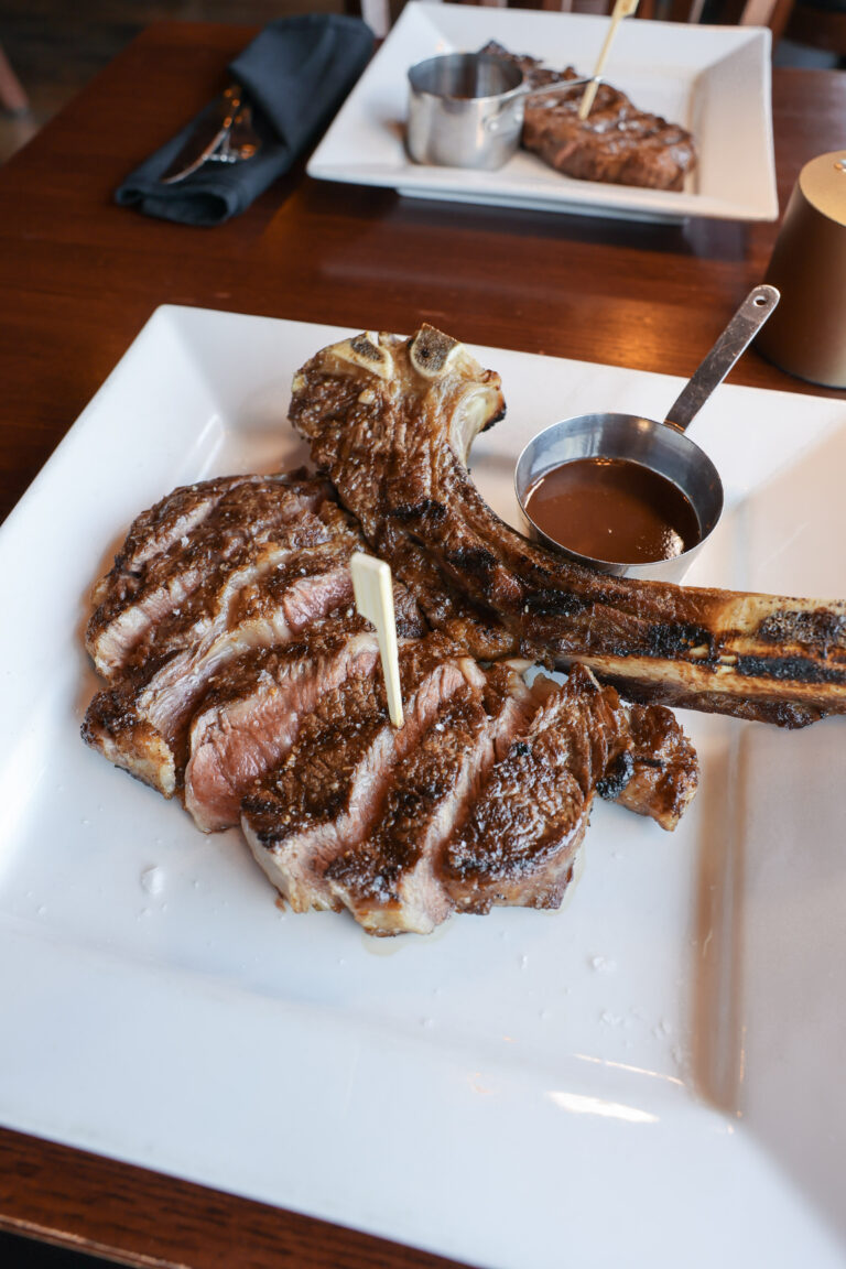 Sliced tomahawk ribeye with steak sauce