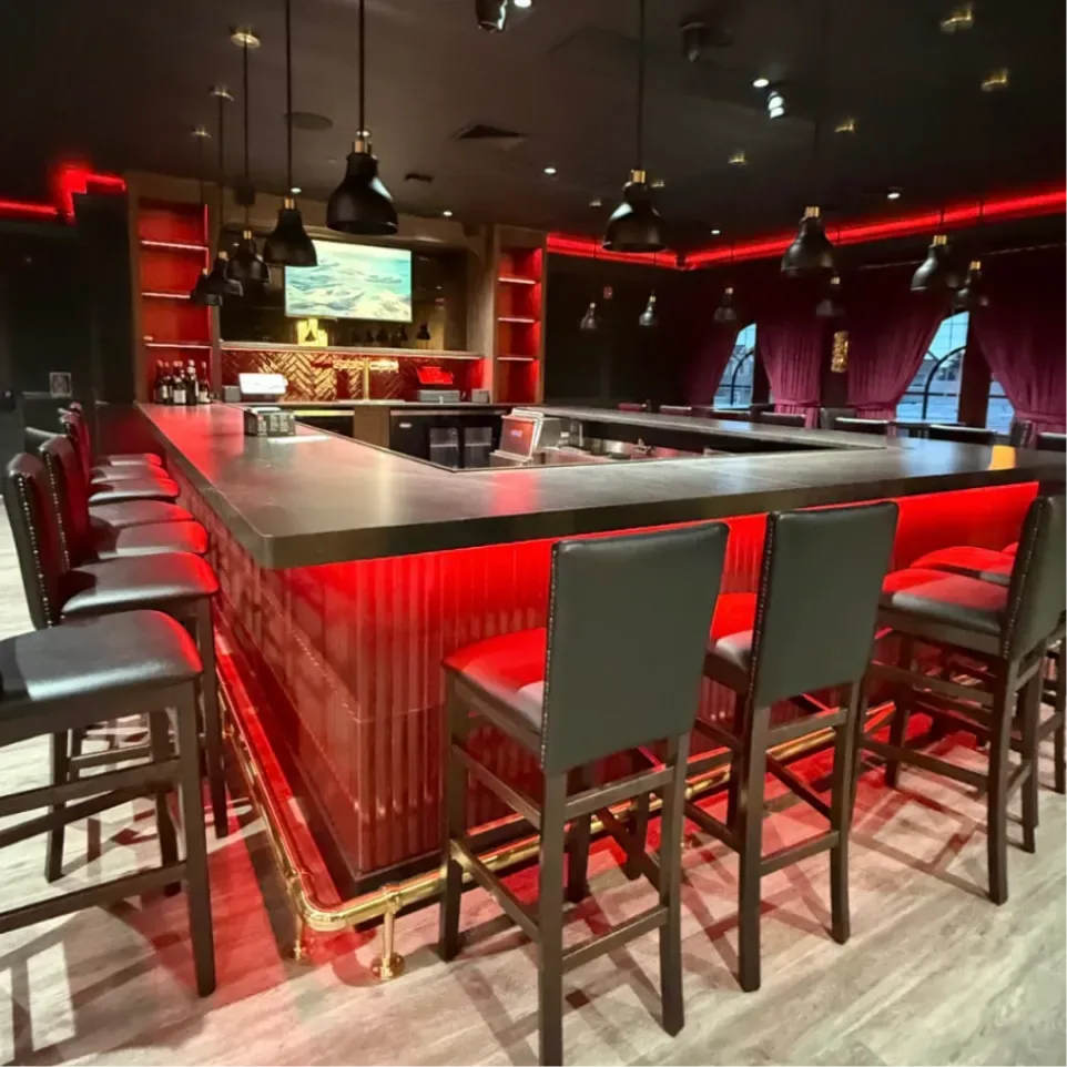 Bar lit in red with leather bar stools at Sinner's Kenilworth