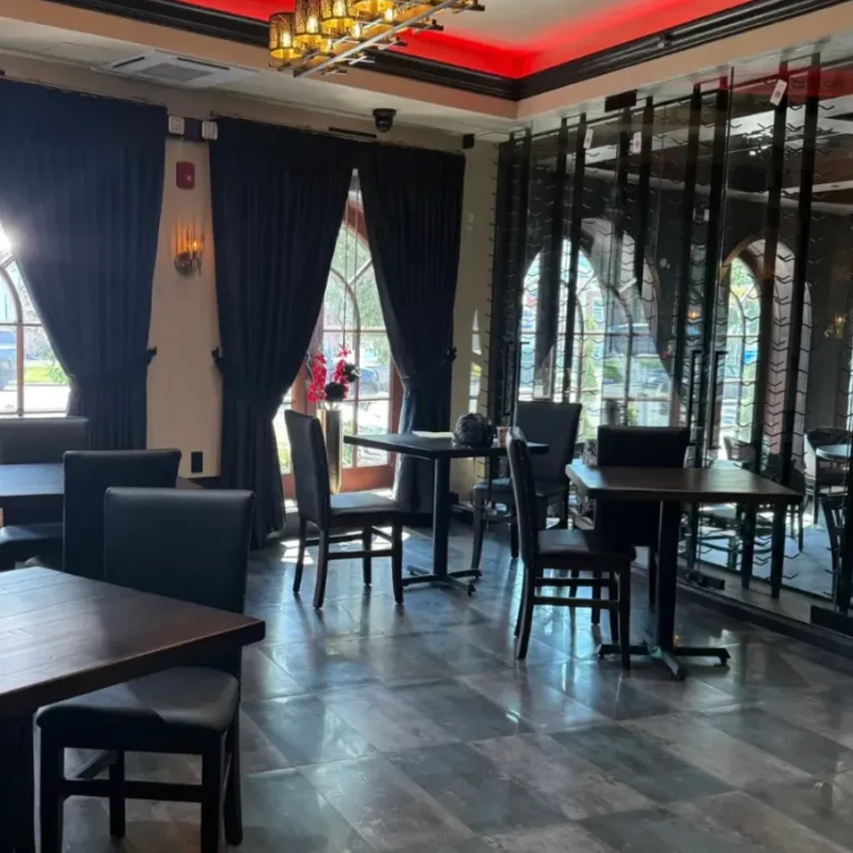 Dining room beside the glass-enclosed wine wall and arched windows at Sinner's Kenilworth
