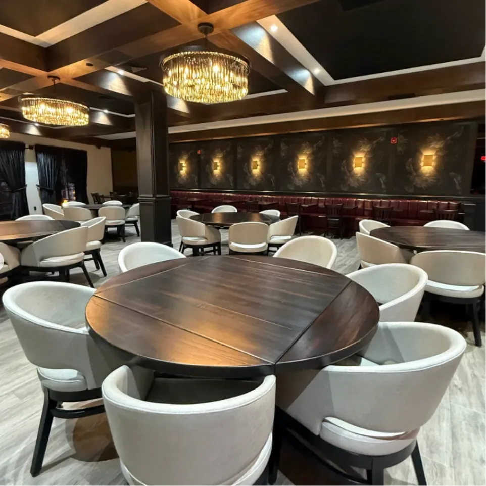 Main dining room at Sinner's Kenilworth with crystal chandeliers, round tables and a red leather banquette