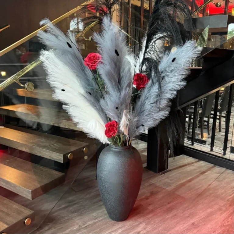 Floating wood staircase with brass railing and a pampas arrangement at Sinner's Kenilworth