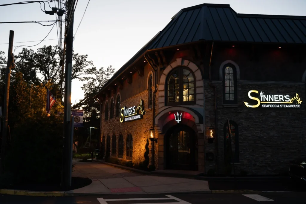 Sinner's Seafood & Steakhouse at 572 Boulevard, Kenilworth, NJ at dusk, its stone front and signs lit up